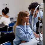 Estudantes universitários diversos colaboram em um experimento científico em laboratório.