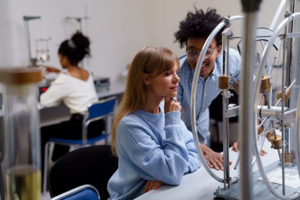 Estudantes universitários diversos colaboram em um experimento científico em laboratório.