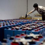 Profissional verifica um conjunto de baterias industriais dentro de uma instalação de armazenamento de energia.