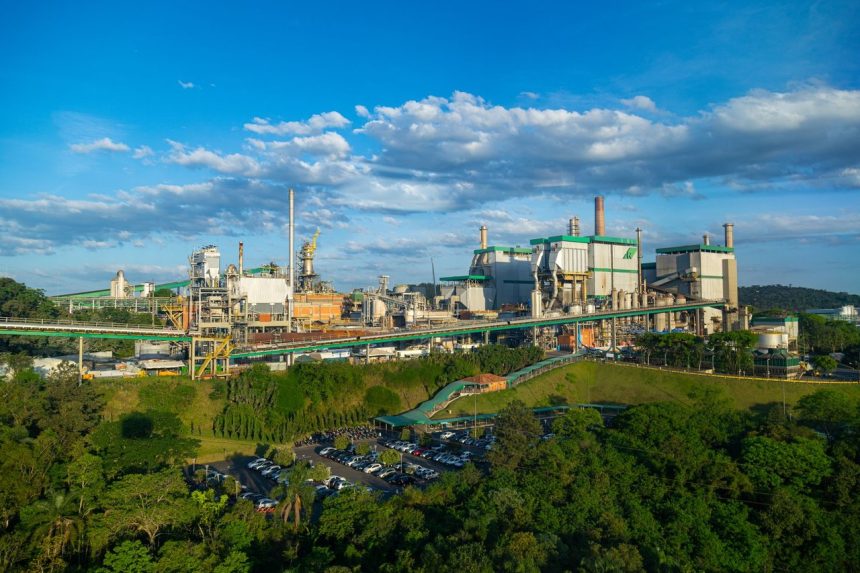 Vista aérea de um complexo industrial cercado por áreas verdes.