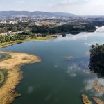 Vista aérea do reservatório de Jundiaí, cercado por áreas verdes e pela paisagem urbana.